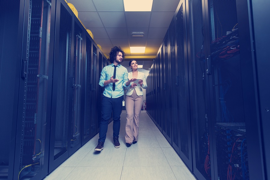 man and woman through data center with server racks<br />
