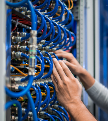 IT technician rewiring ethernet cables on server rack